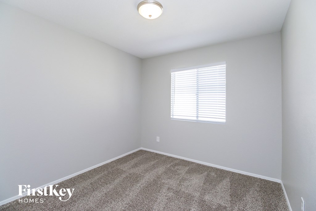 an empty room with carpet and a window