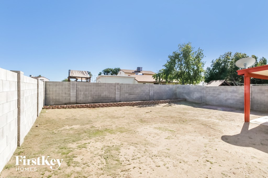 a backyard with a basketball court and a fence