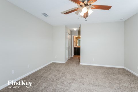 a living room with carpet and a ceiling fan