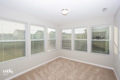a living room with windows and carpeting and a large window