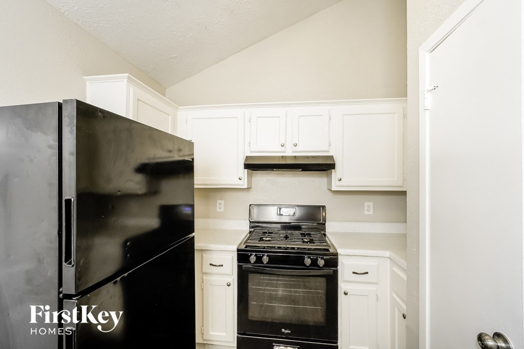 a kitchen with white cabinets and a stove and refrigerator