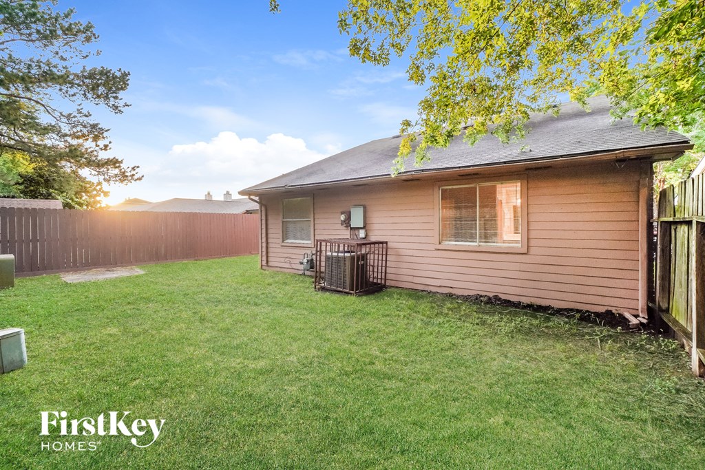 a small house with a yard and a fence
