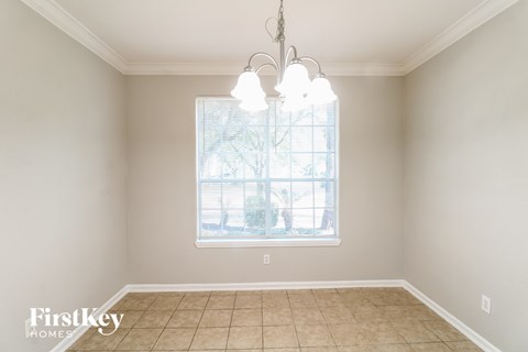 a dining room with a large window and a tiled floor