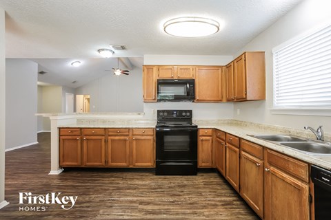 a kitchen with wooden cabinets and a black dishwasher