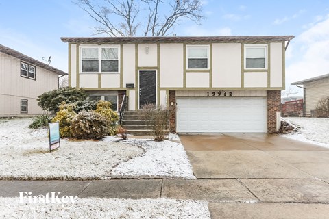 a cream colored house with white snow on the ground