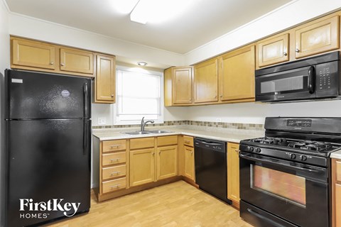 a kitchen with black appliances and wooden cabinets