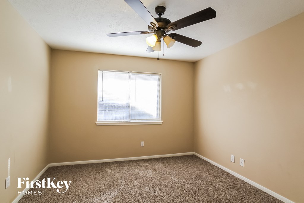 a bedroom with a ceiling fan and a window