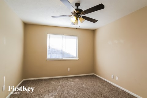 a bedroom with a ceiling fan and a window