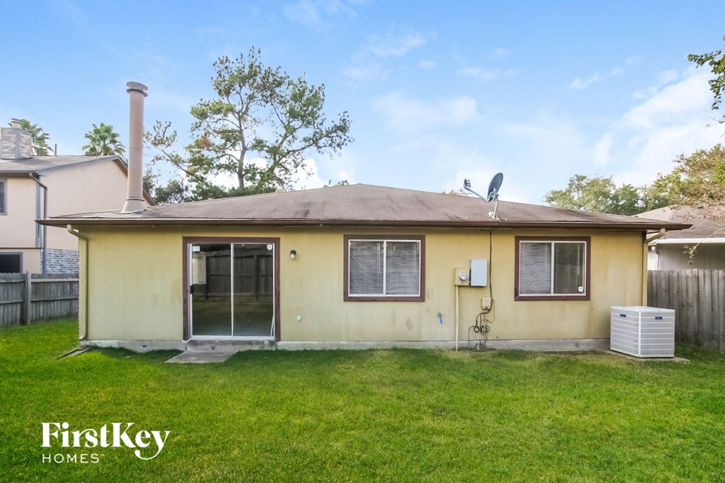 the front of a yellow house with a yard and grass