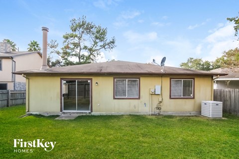 the front of a yellow house with a yard and grass