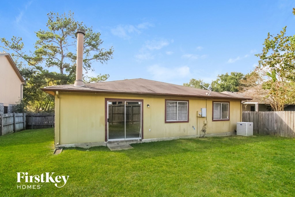 the backyard of a yellow house with a yard and grass