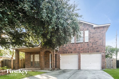 A brick house with a tree in front of it.