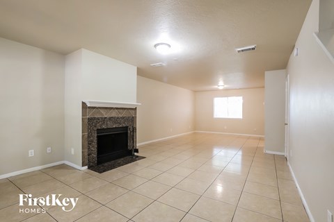 A living room with a fireplace and tiled floor.