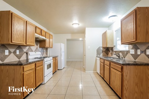 A kitchen with wooden cabinets and a tiled floor.
