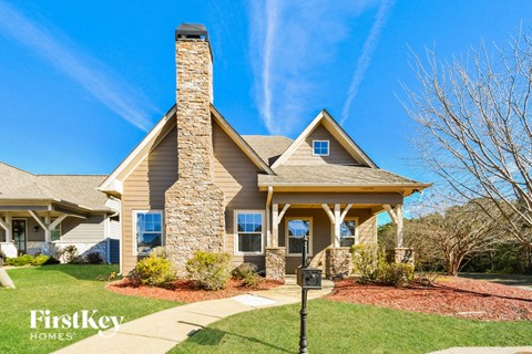a home with a stone chimney on the front of it