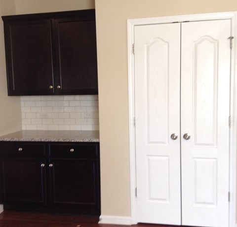 a kitchen with black and white cabinets and white doors