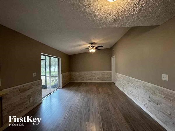 A room with wooden floors and a ceiling fan.