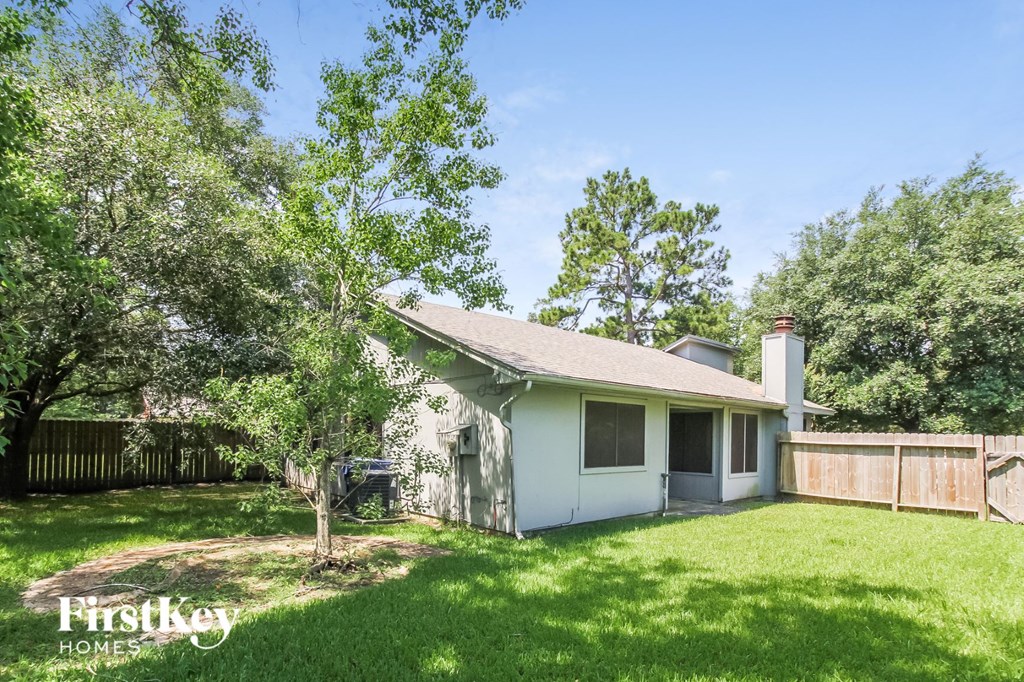 a small white house with a yard and trees