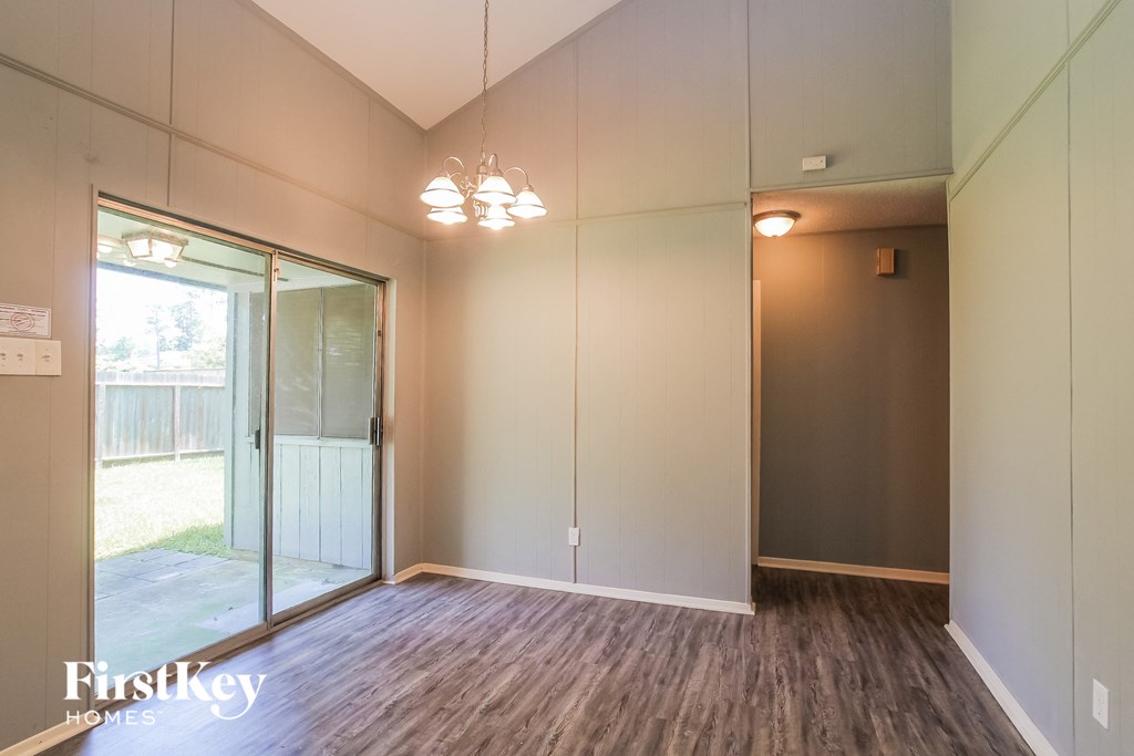 a living room with a large mirror and wood flooring