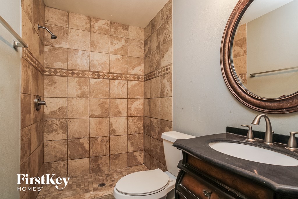 a bathroom with a toilet and a sink and a mirror