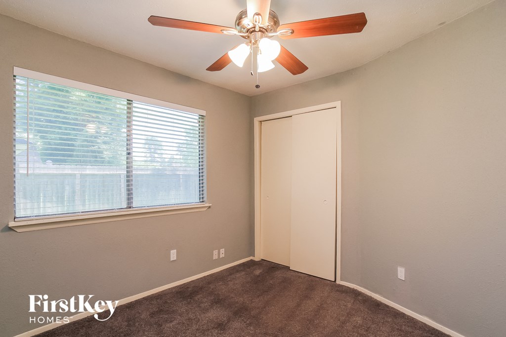 the living room has a ceiling fan and a large window