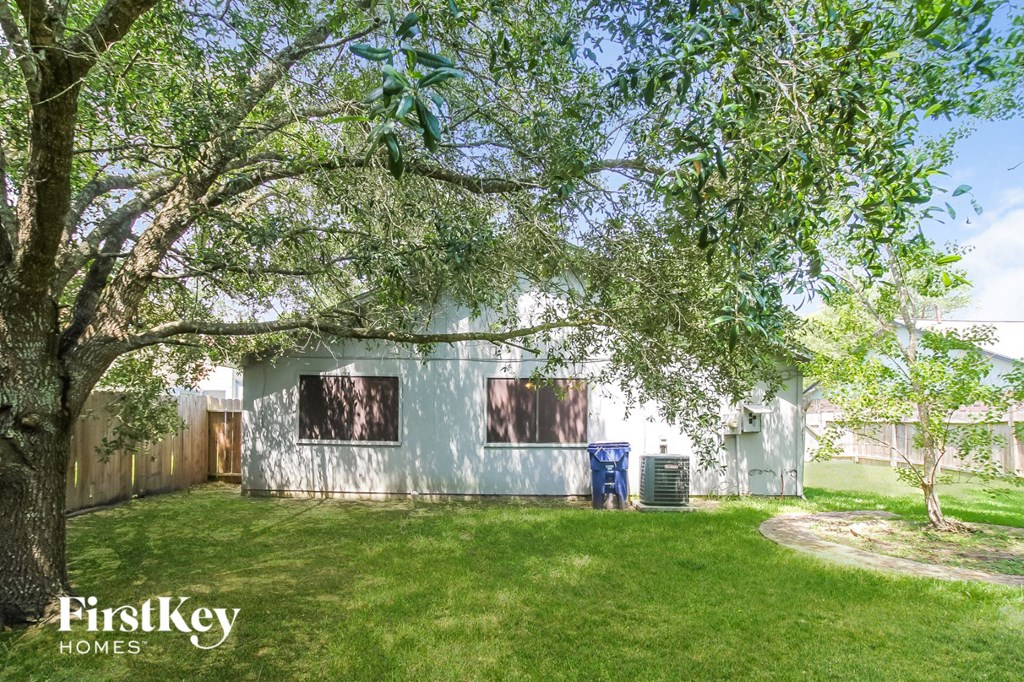 a house with a yard and trees in front of it