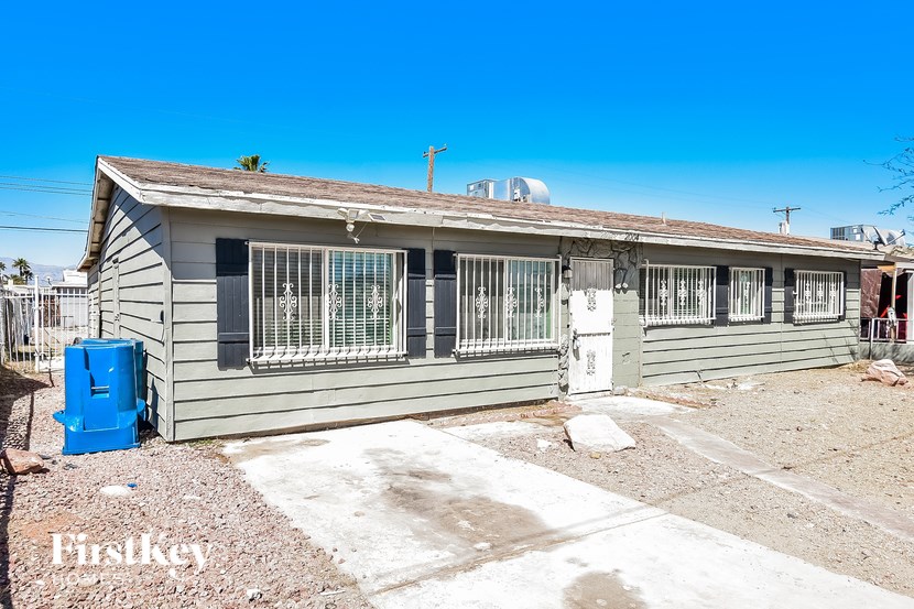 A house with a blue container in front of it.