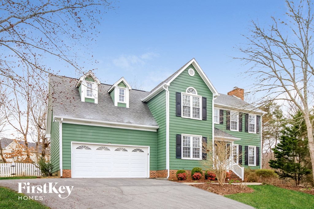 a green house with a white garage door