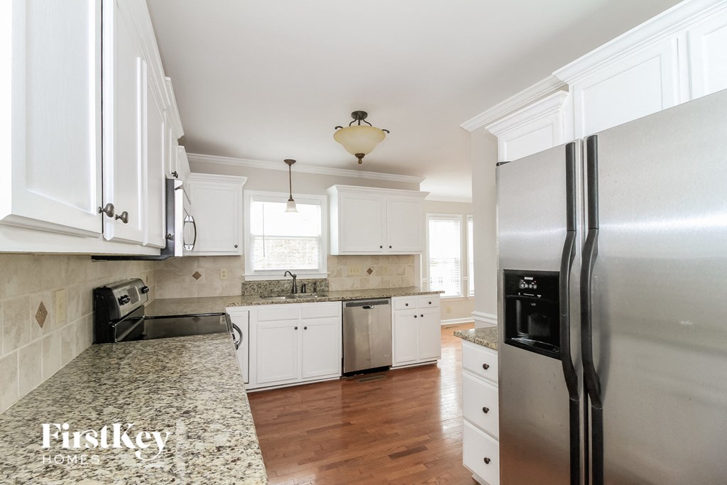 a kitchen with white cabinets and stainless steel appliances