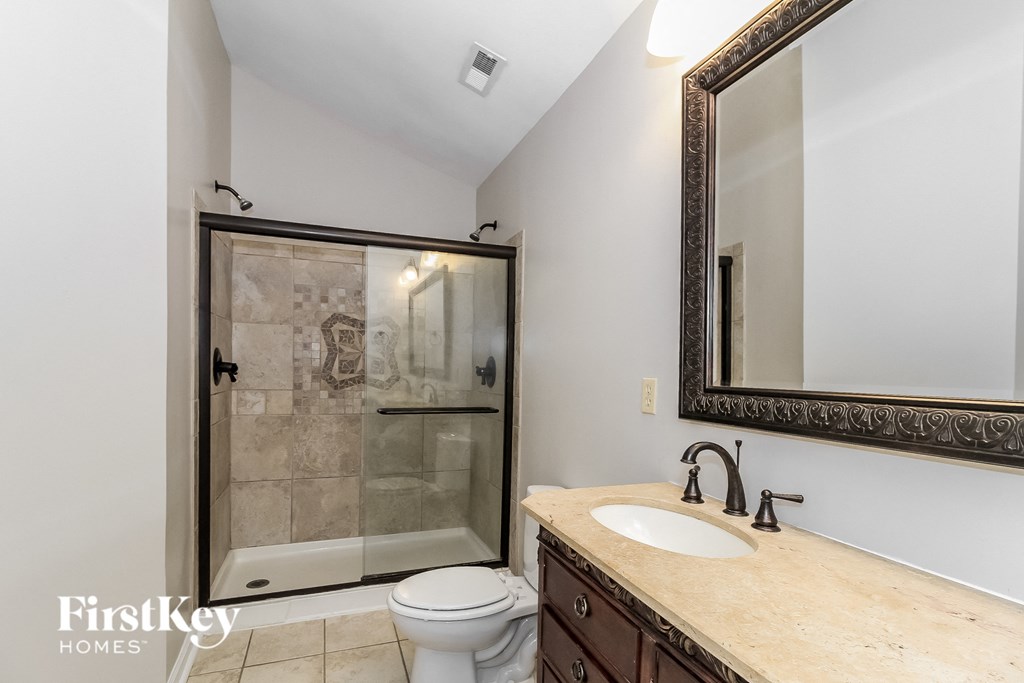 a bathroom with a shower toilet and sink and a mirror