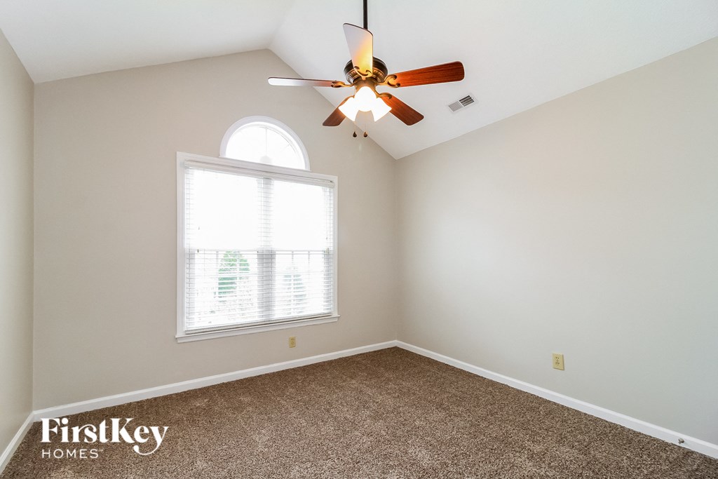 a bedroom with a ceiling fan and a window