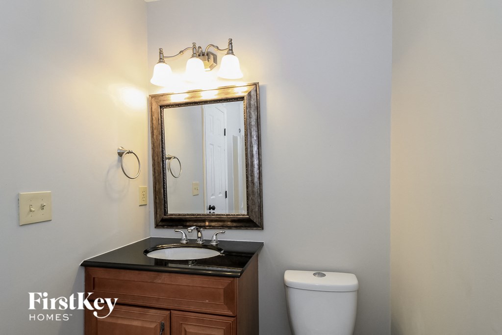a bathroom with a mirror and a sink and a toilet