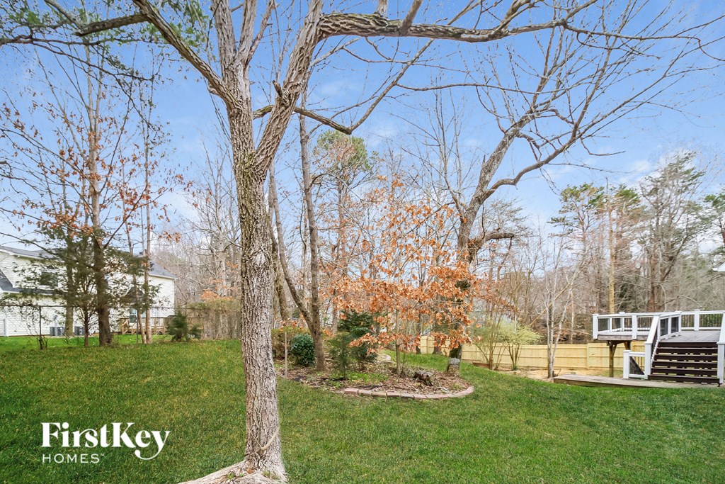 a yard with trees and a house in the background