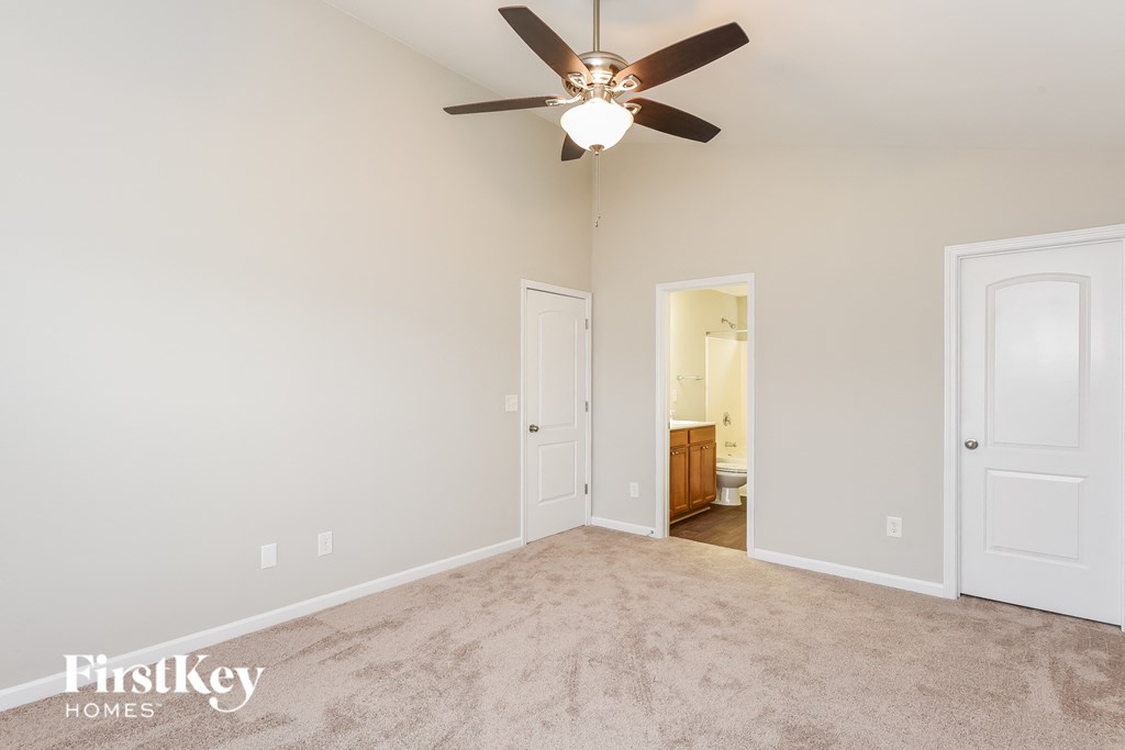 a living room with carpet and a ceiling fan