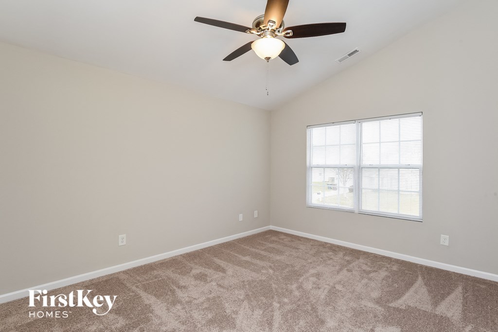 a bedroom with a ceiling fan and a window