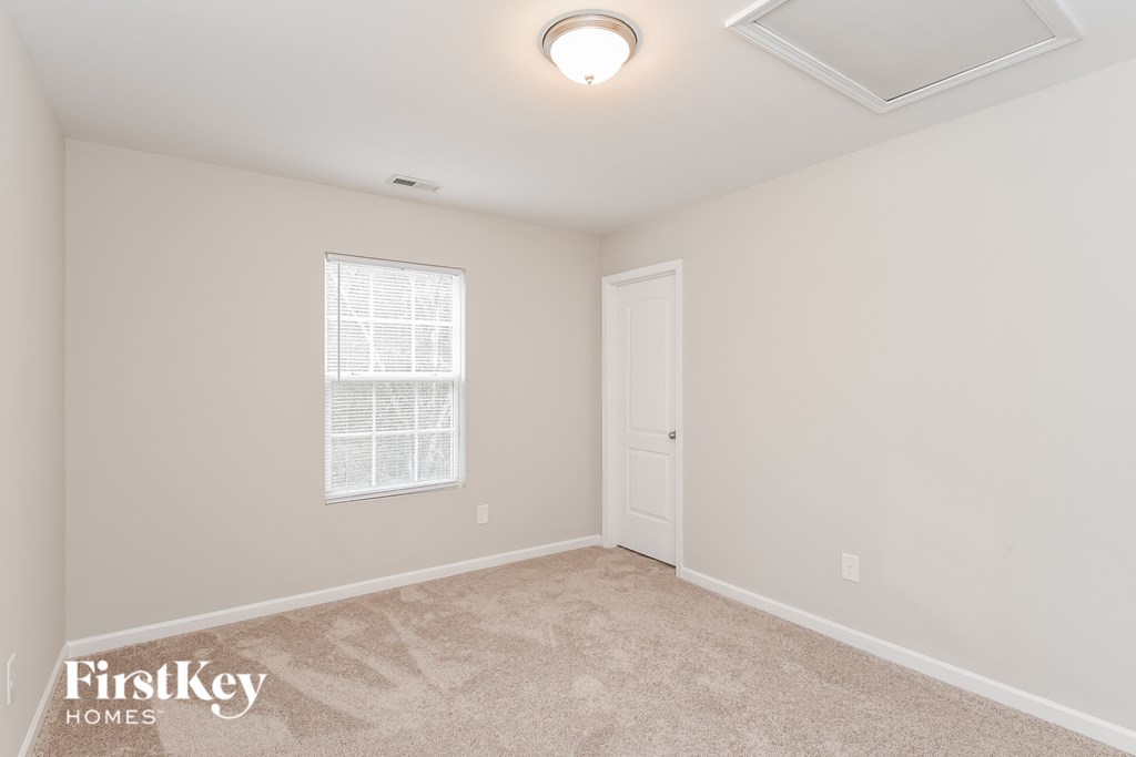 a bedroom with a carpeted floor and a white door