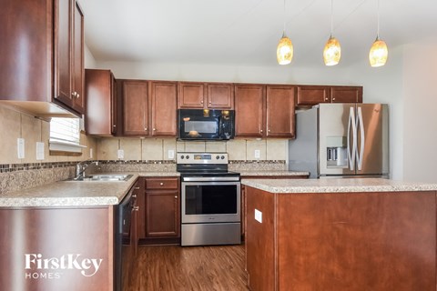 A kitchen with brown cabinets and a FirstKey Homes sign.