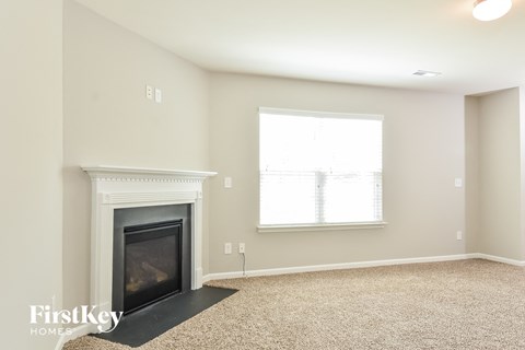 A living room with a fireplace and a window.