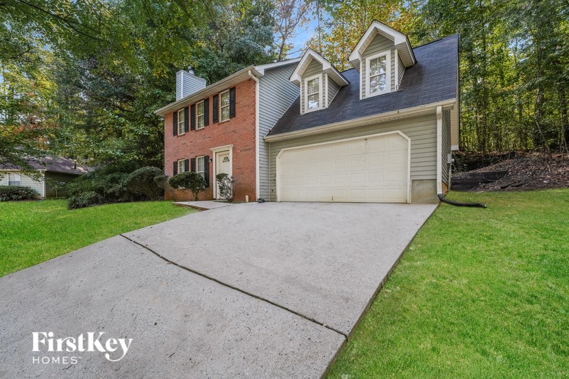 a white garage door on a brick house with a driveway