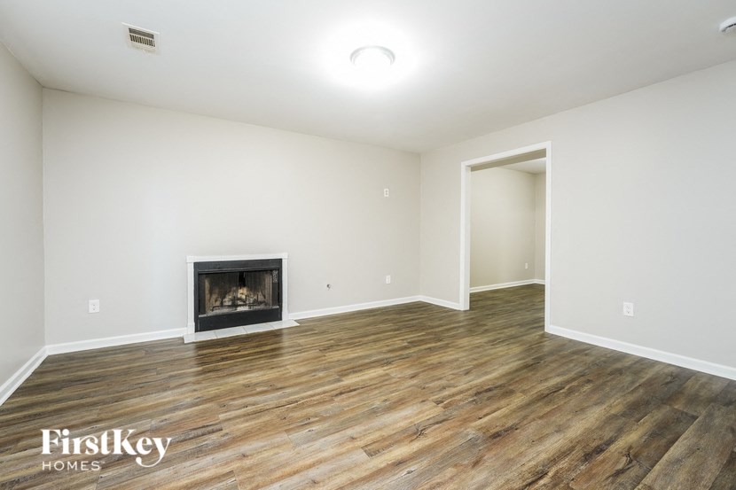 a living room with a fireplace and wooden floors