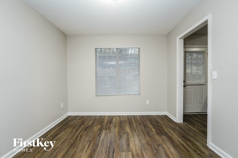 a living room with wood flooring and a door to a hallway