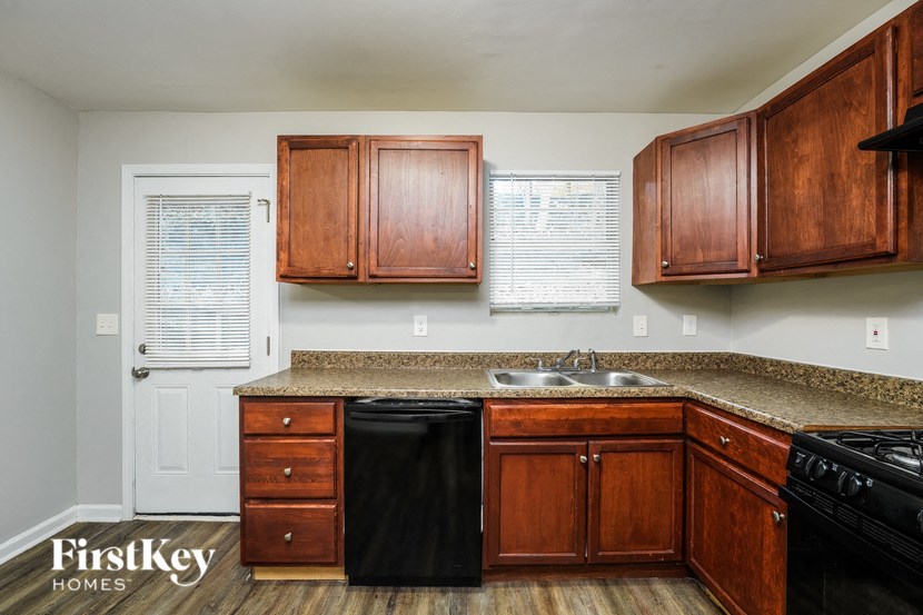 a kitchen with wooden cabinets and a black dishwasher