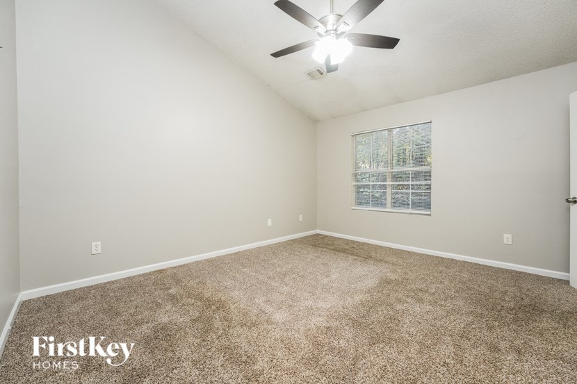 a room with carpet and a ceiling fan