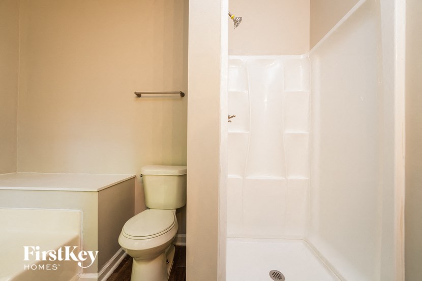 a bathroom with a toilet and a shower