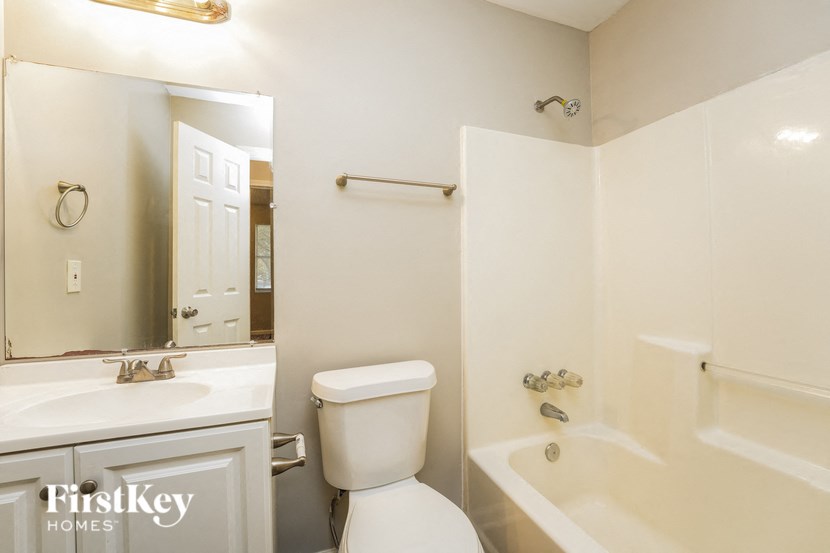 a white bathroom with a toilet and a tub and a sink