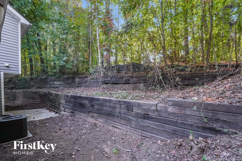 a backyard with a retaining wall and trees