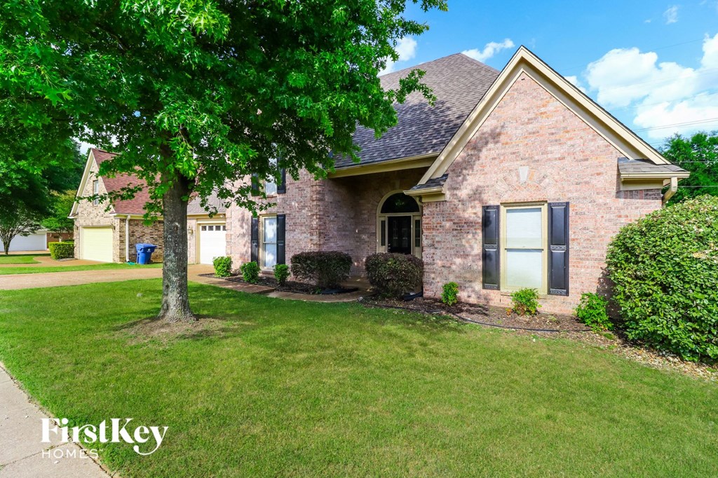 A brick house with a tree in front of it.