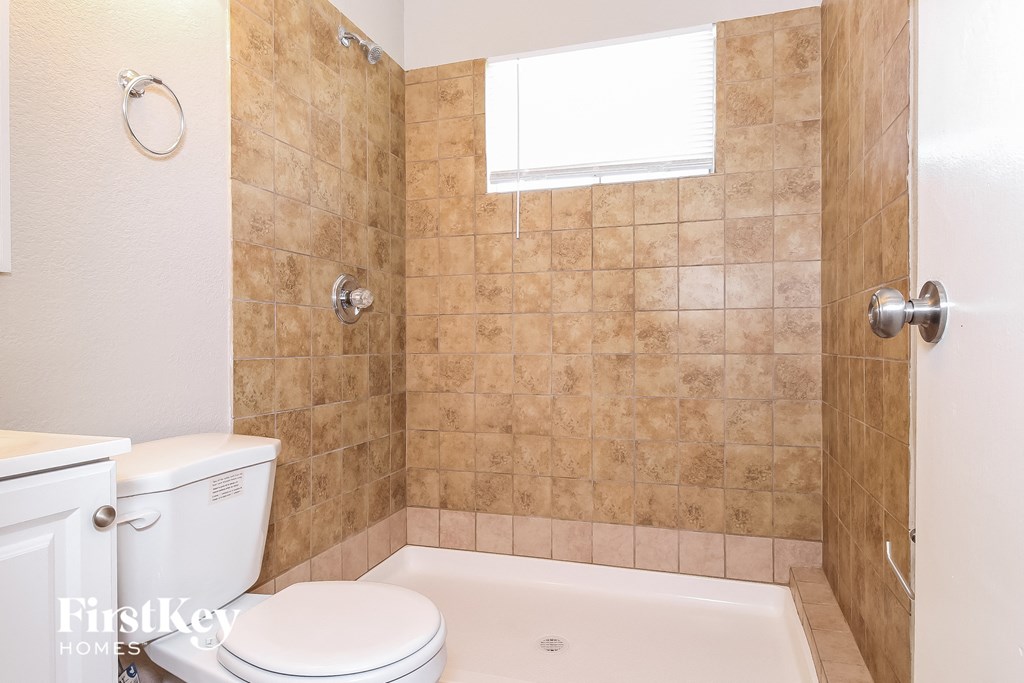 a bathroom with a toilet and a tub and a shower