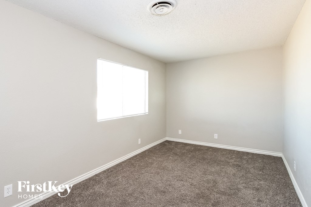 an empty room with carpet and a window