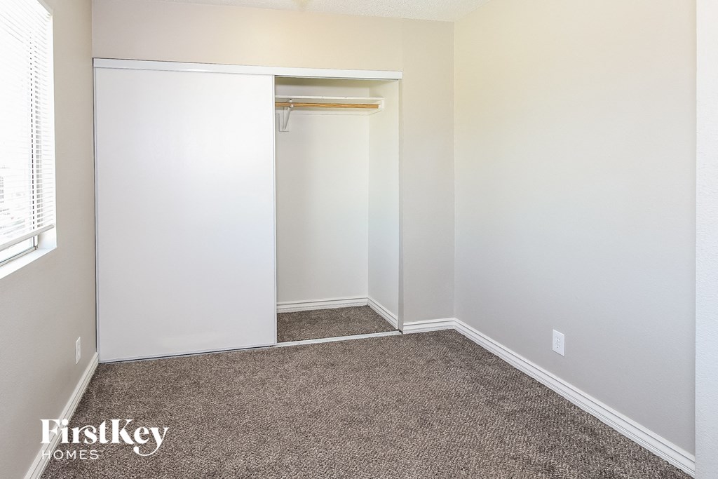 a bedroom with a closet and a carpeted floor
